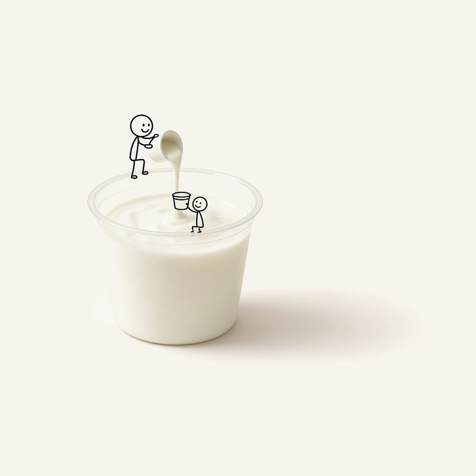 Yogurt microwave smoothie in a clear cup, with two figures pouring and catching yogurt